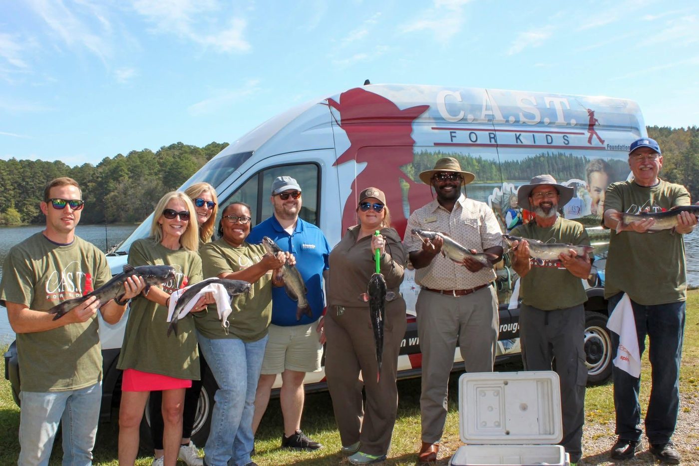 Kiwanis volunteers with C.A.S.T. for Kids holding fish they caught